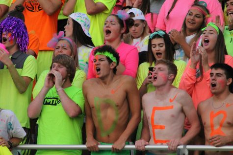 The student section gets lit with neon night. 