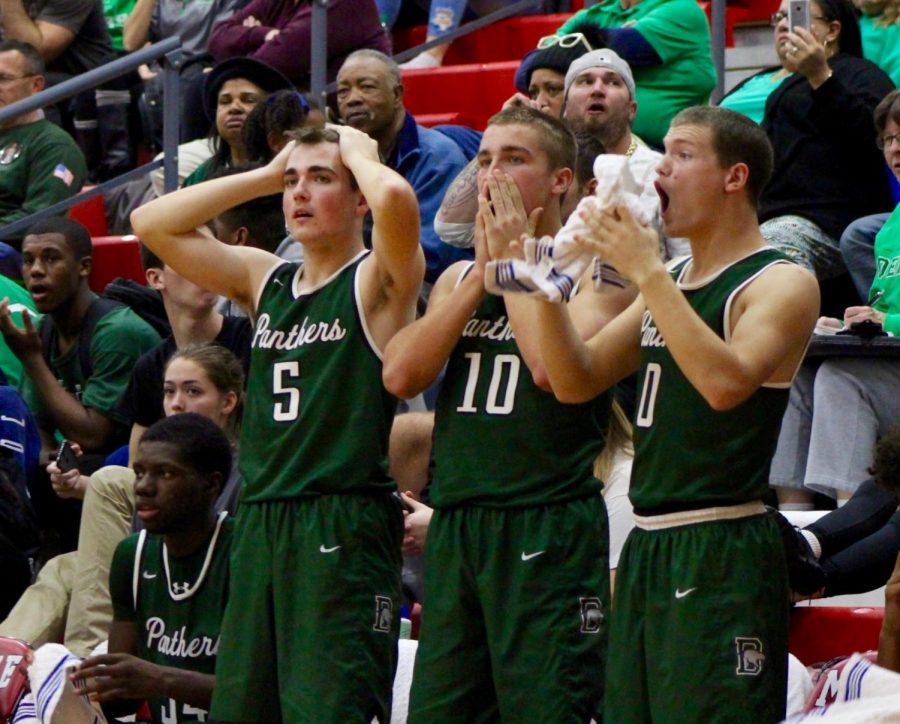 Junior Jared Mocaby, sophomore Jacob Karsak, and junior Dax Benway react to a free throw point by Derby.  The free throw ended up tying the game close to the end of the fourth quarter.