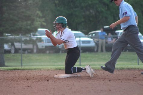 Junior Madison Young slides into second base, makes it safely, gets on her knees, and starts encouraging her team.