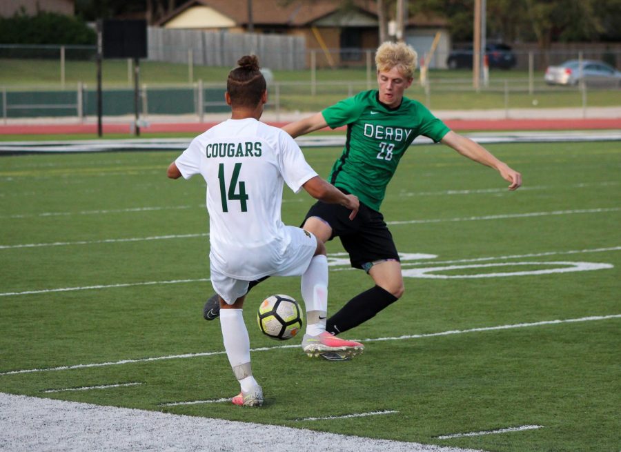 Junior Matthew Young kicks the ball away from his  opponent.