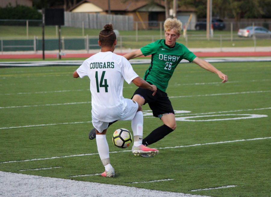 Junior+Matthew+Young+kicks+the+ball+away+from+his++opponent.