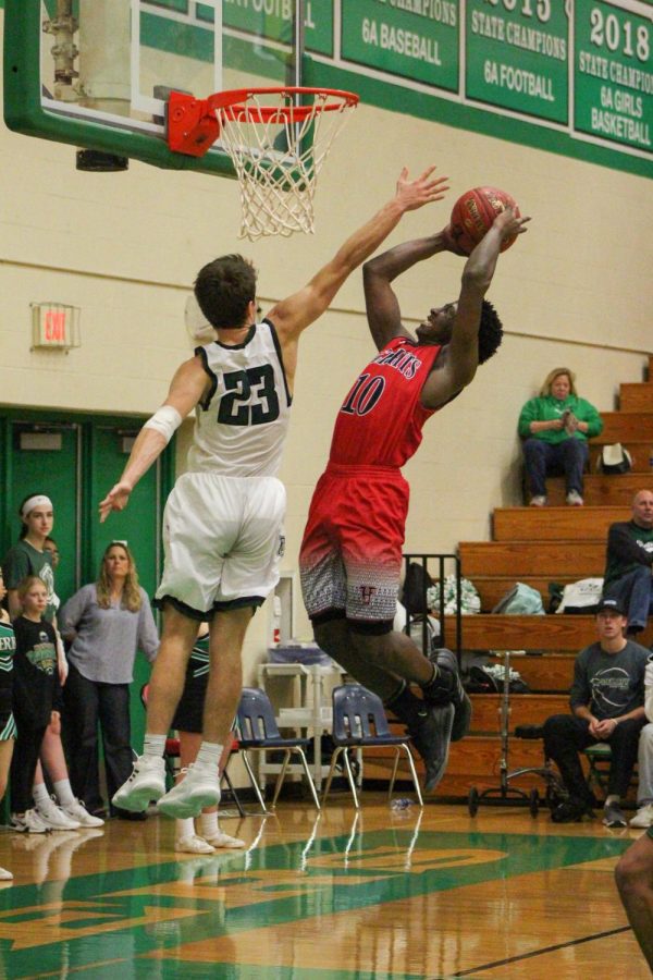 Senior Clayton Hood jumps into the air to block a shot from his Heights opponent.