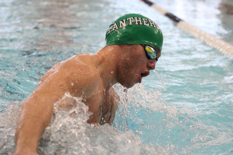 Senior Nathaniel Baucum performs an open turn during the 100 meter breast stroke.