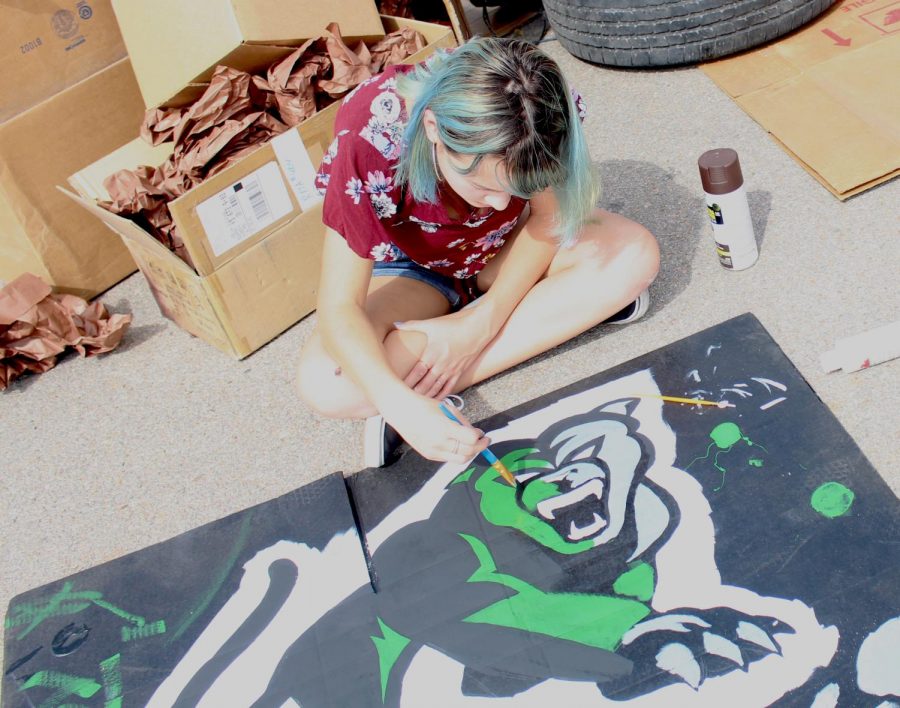 Senior Skylar Rivera paints the new panther graphic for the senior class float.