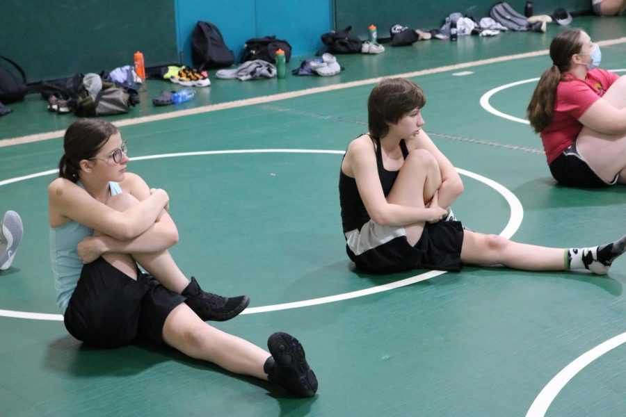 Two wrestlers warm up for practice with the team.