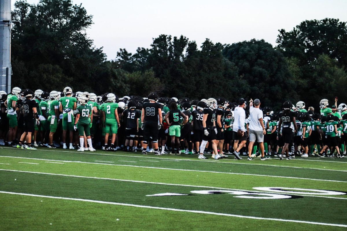 All football players huddle on the field.