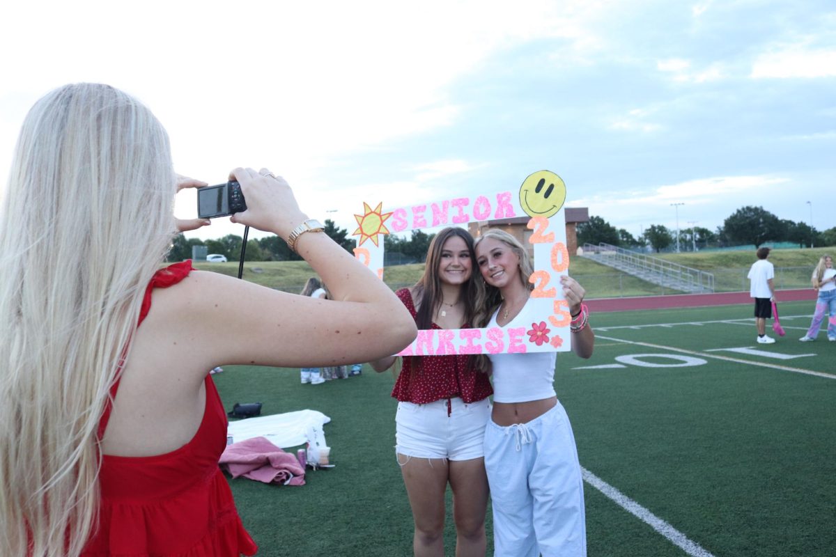 Senior duo poses for a picture with a Senior Sunrise sign