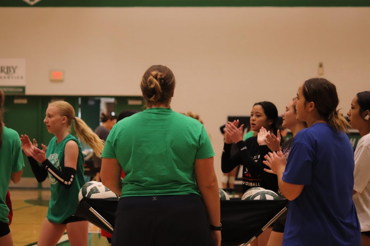 Volleyball players applaud for each other at volleyball practice.