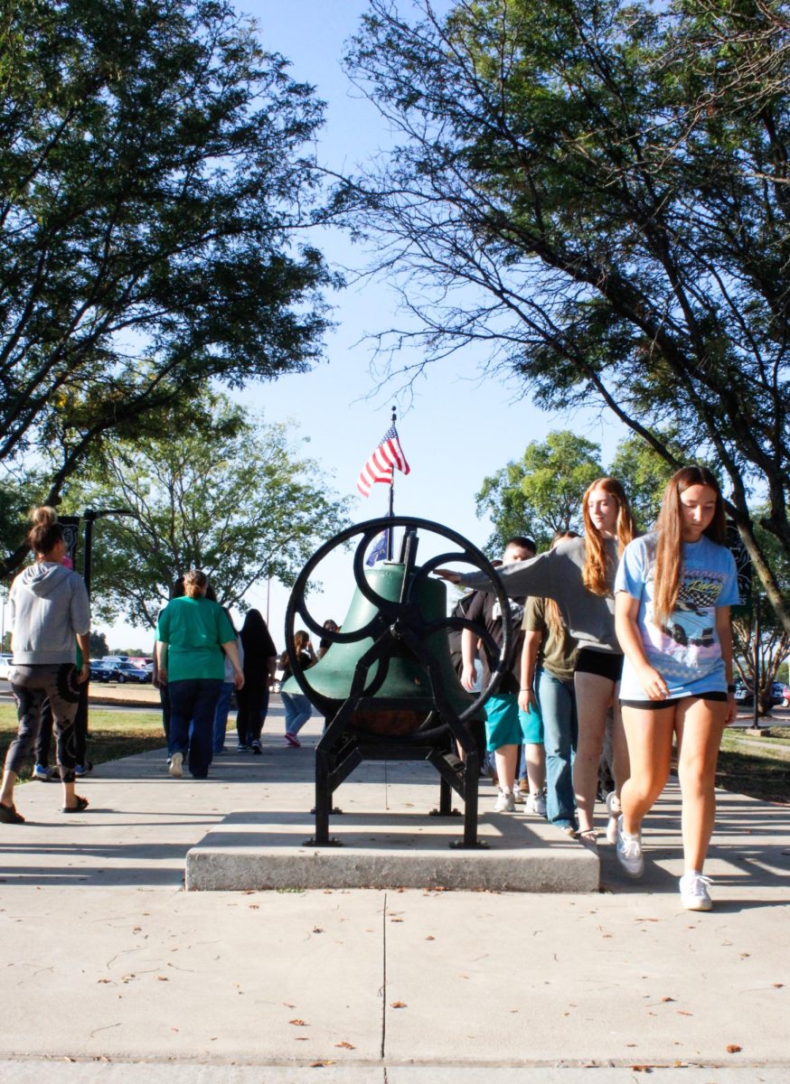 Students walk to ring the bell. 