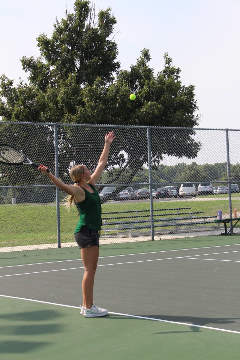 Tennis player prepares to hit tennis ball at practice.