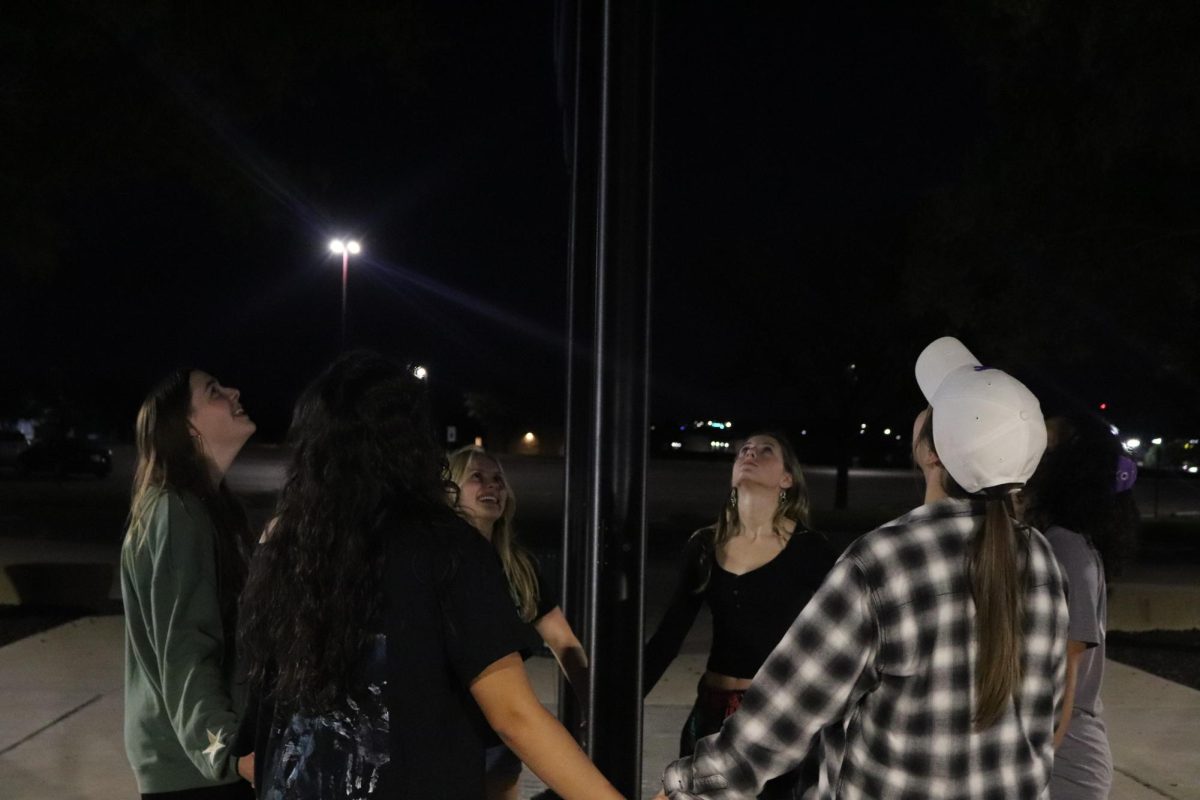 Students looking at the flag pole. 