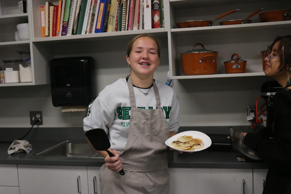 Sophomore Caitlyn Reinard poses for the camera after making pancakes. 