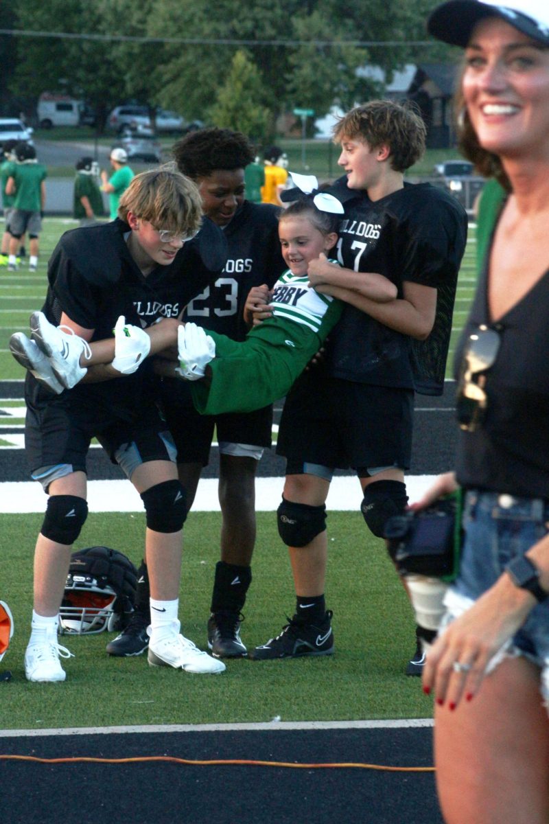 Players lift up cheerleader.