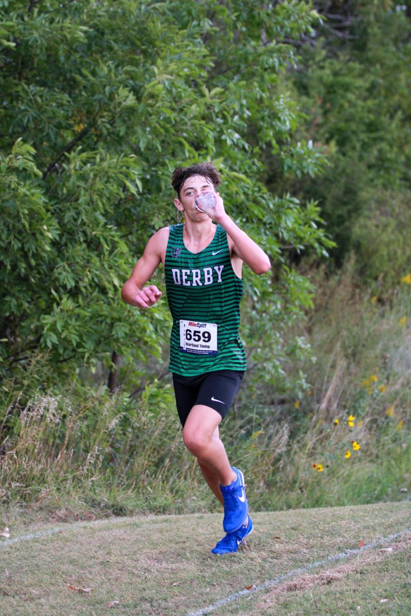 Senior Lucas Kreutzer is about to finish mile two and drinks water.