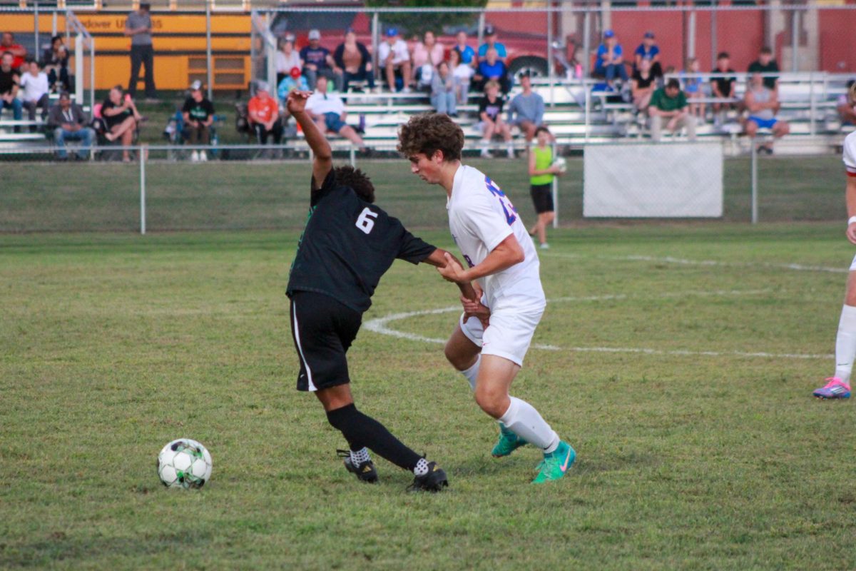 Player blocks opponent from stealing ball. 