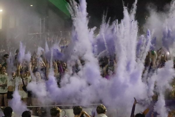 Student section throws purple powder into the air.