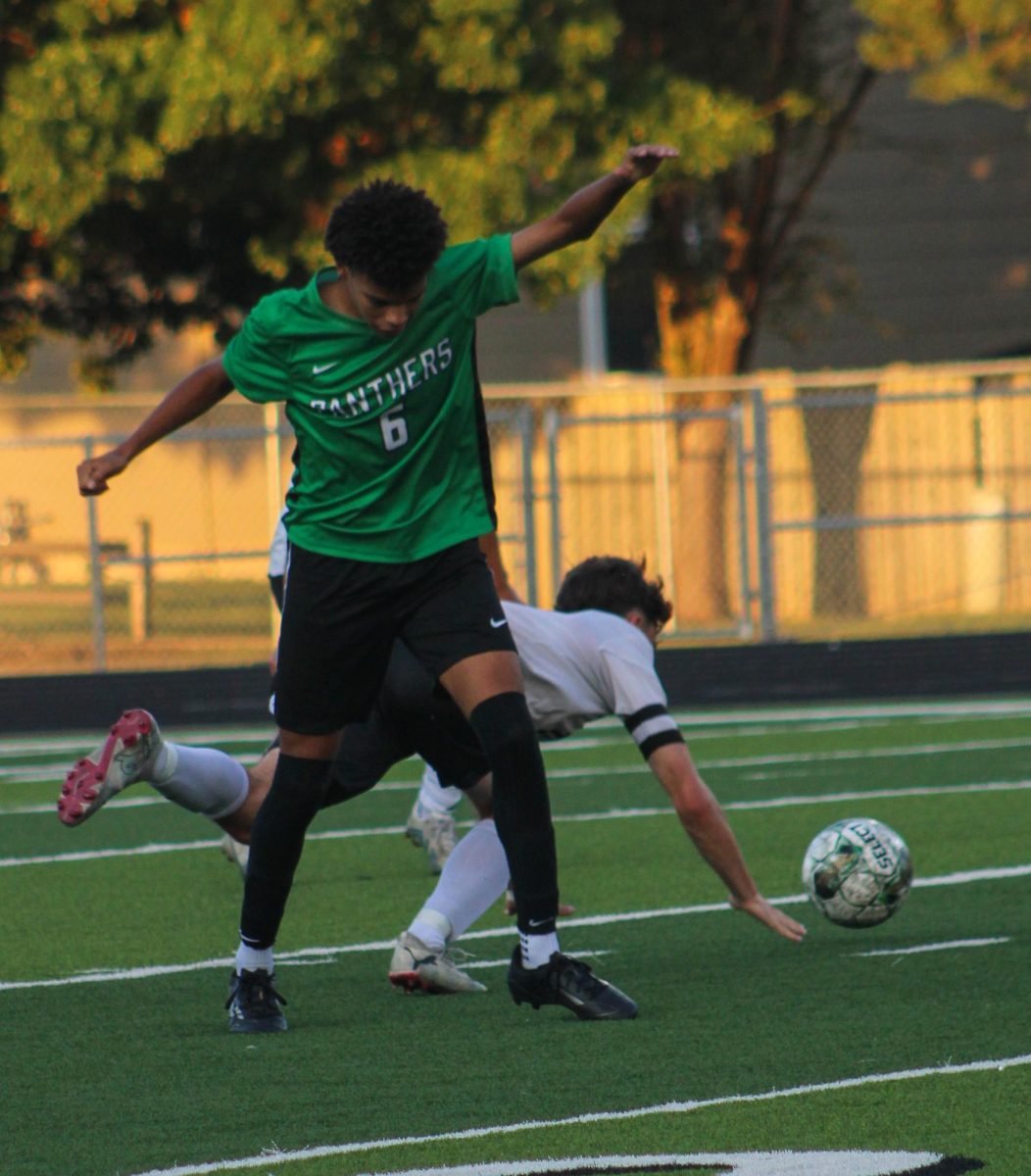 Soccer player Ethan Mbawuike, stumbles as he tries to recover the ball. 