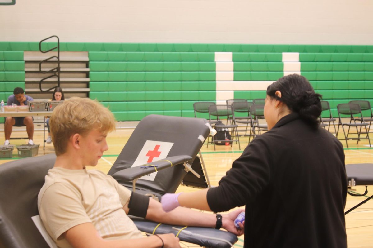 Student gives blood at blood drive.