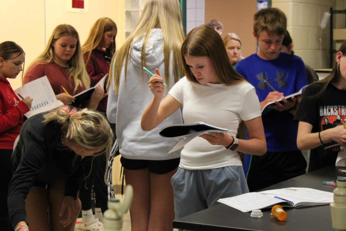 Student looks at the fake body to take notes on.