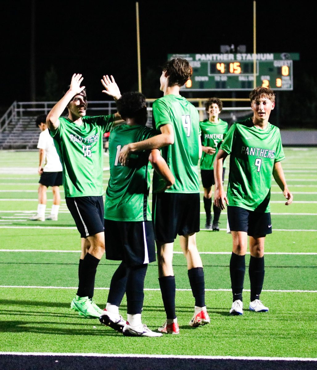 After scoring a goal, junior Nick Bruening celebrates with his teammates.