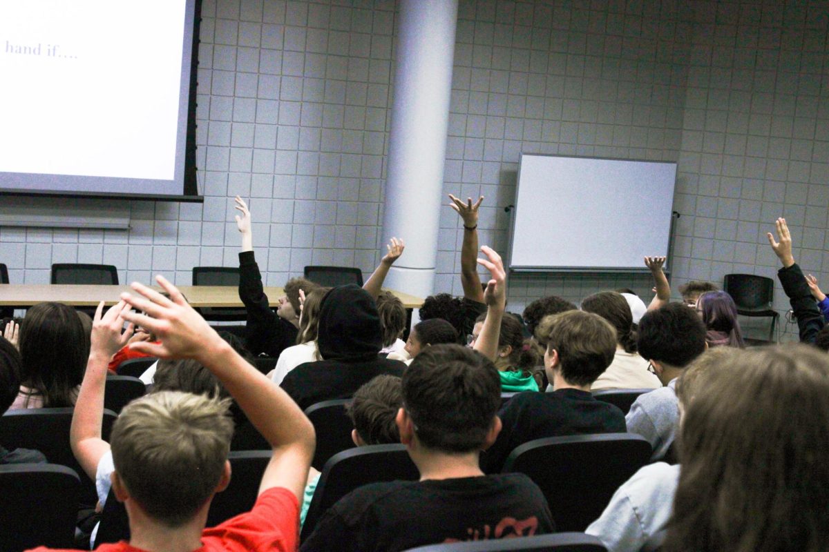 Students raise their hands to answer a question.