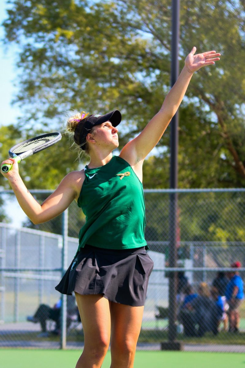 Karlie Demel serves ball during match