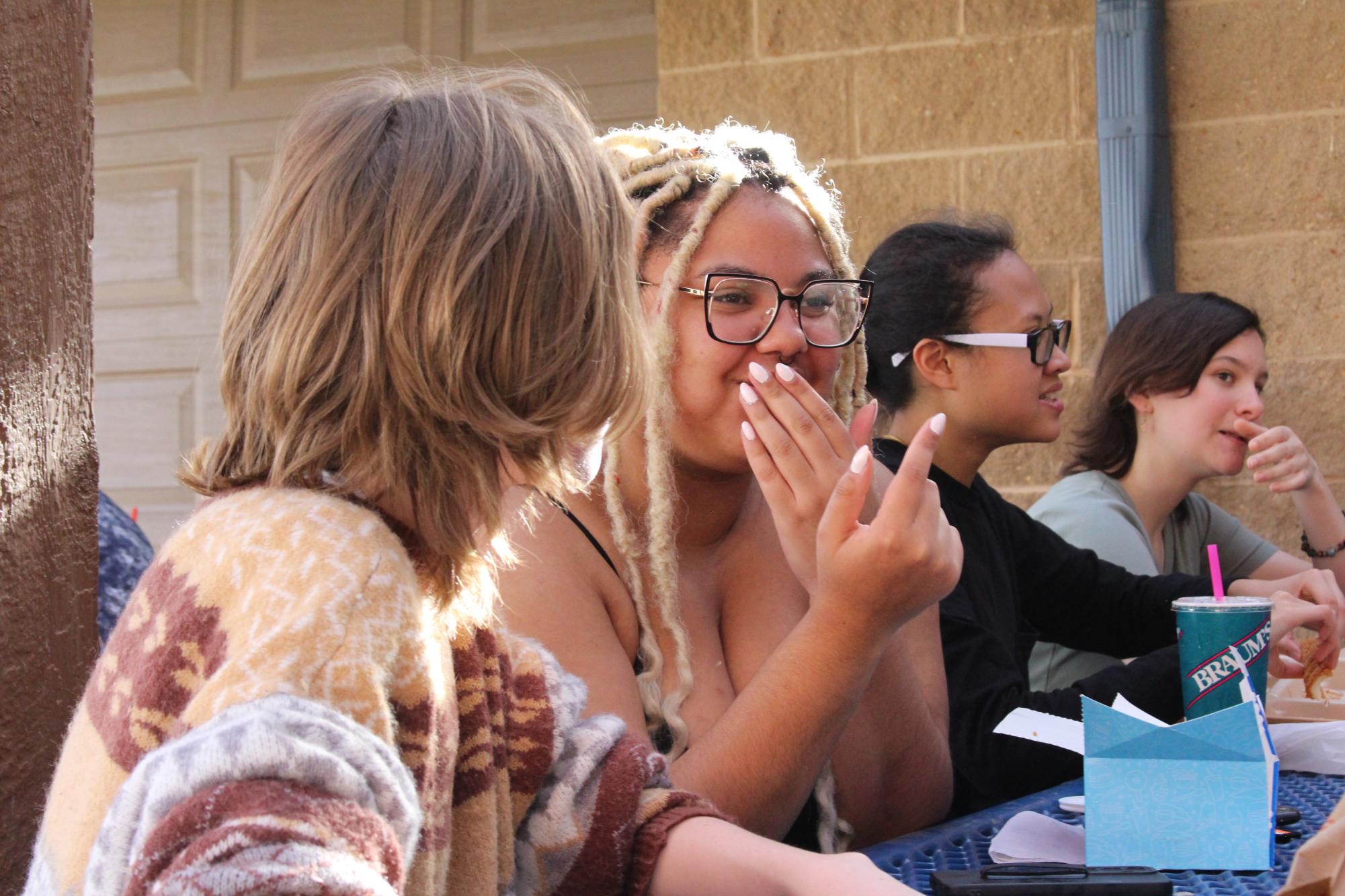 Junior Sydney Vaughn talks to cast members.