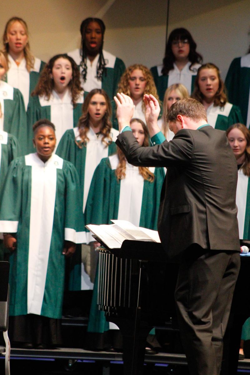 Choir Director Tyler Morris conducts the choir. 