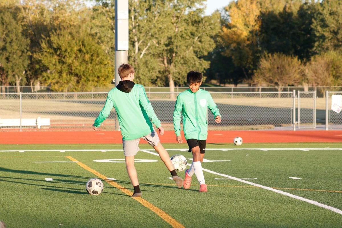 Two players warm up by juggling the ball.