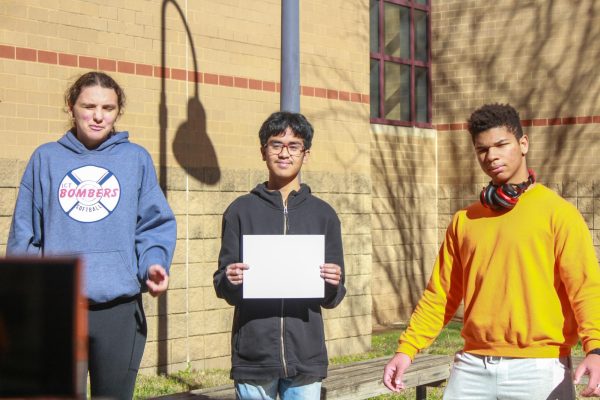 While filming, Adam Lam holds paper with information for their group project in AP European History.