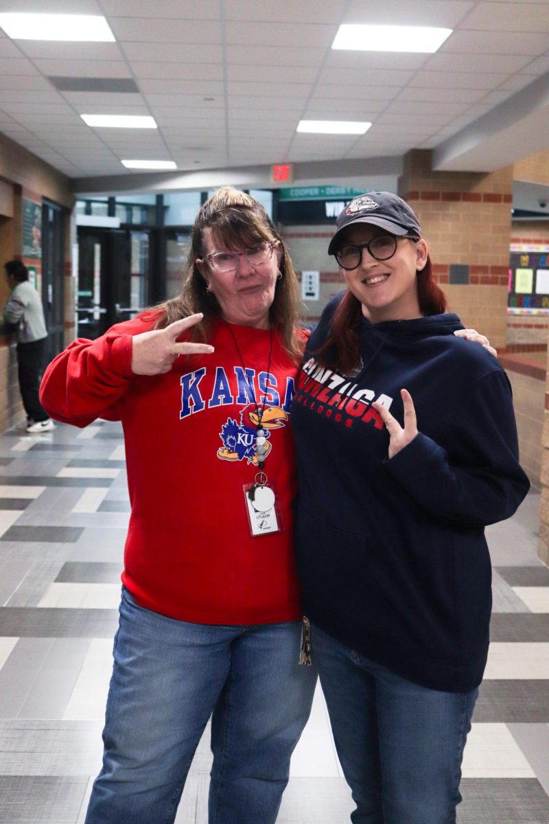 Social Worker Tonia Stoehr and Attendance Clerk Candace Morgan pose for a picture together for the theme, "College Shirt day."