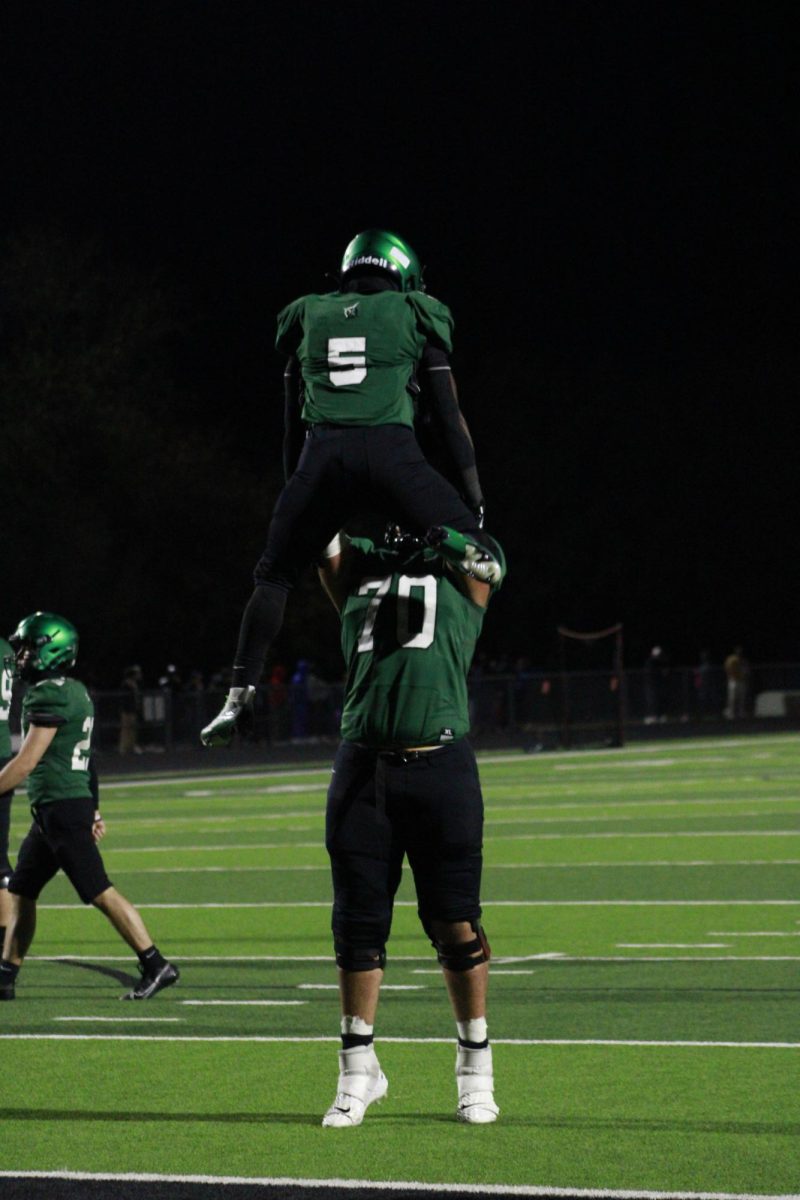 Player lifts another player into the air after a touchdown.