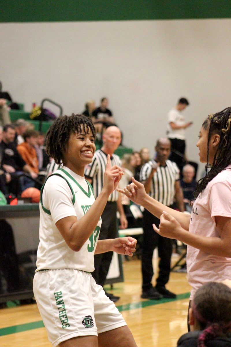 Junior Macayla Askew does her pregame handshake with a manager.