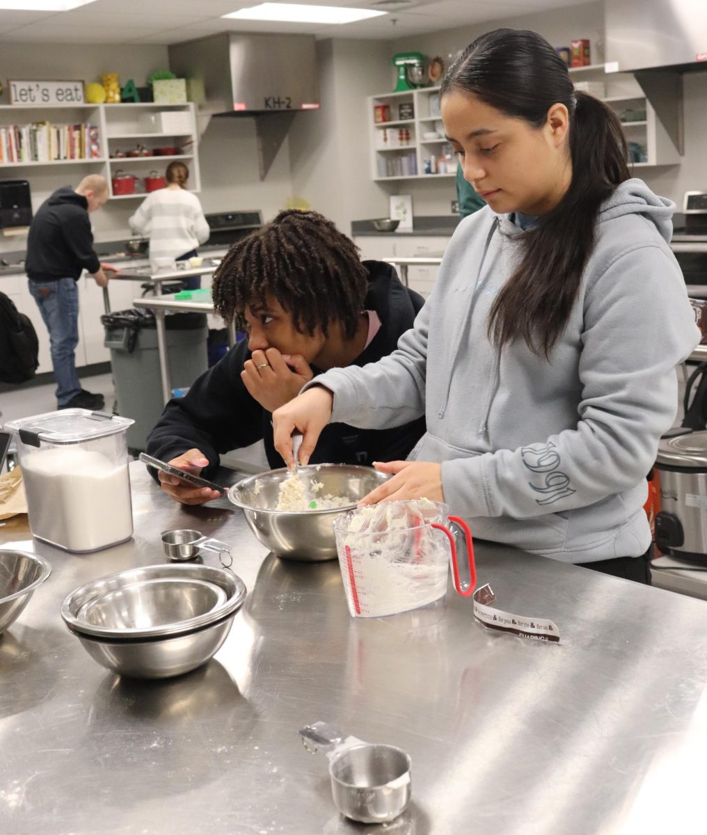 Student stirs cookie dough mix. 