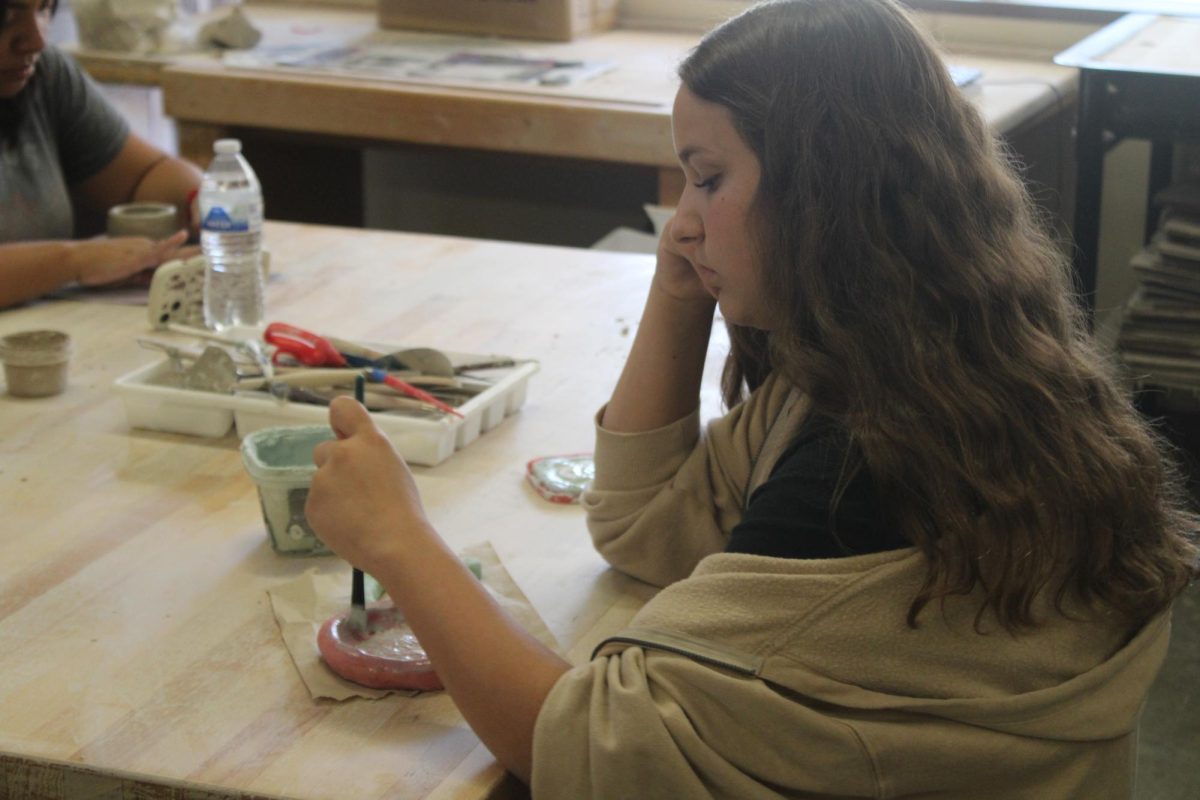 Student paints sculpture.