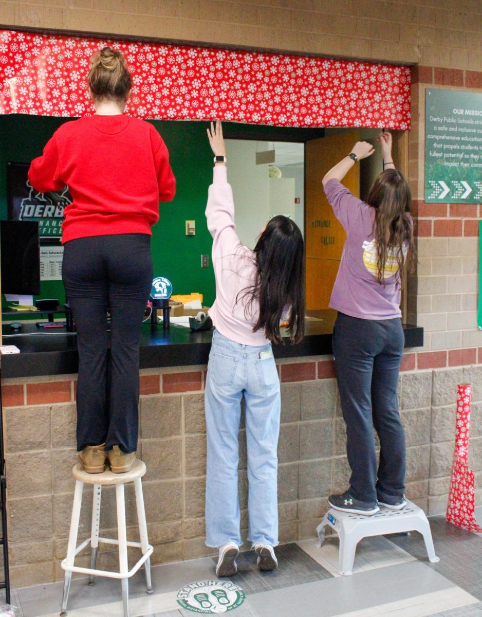 Three NHS members work together to wrap the finance office.