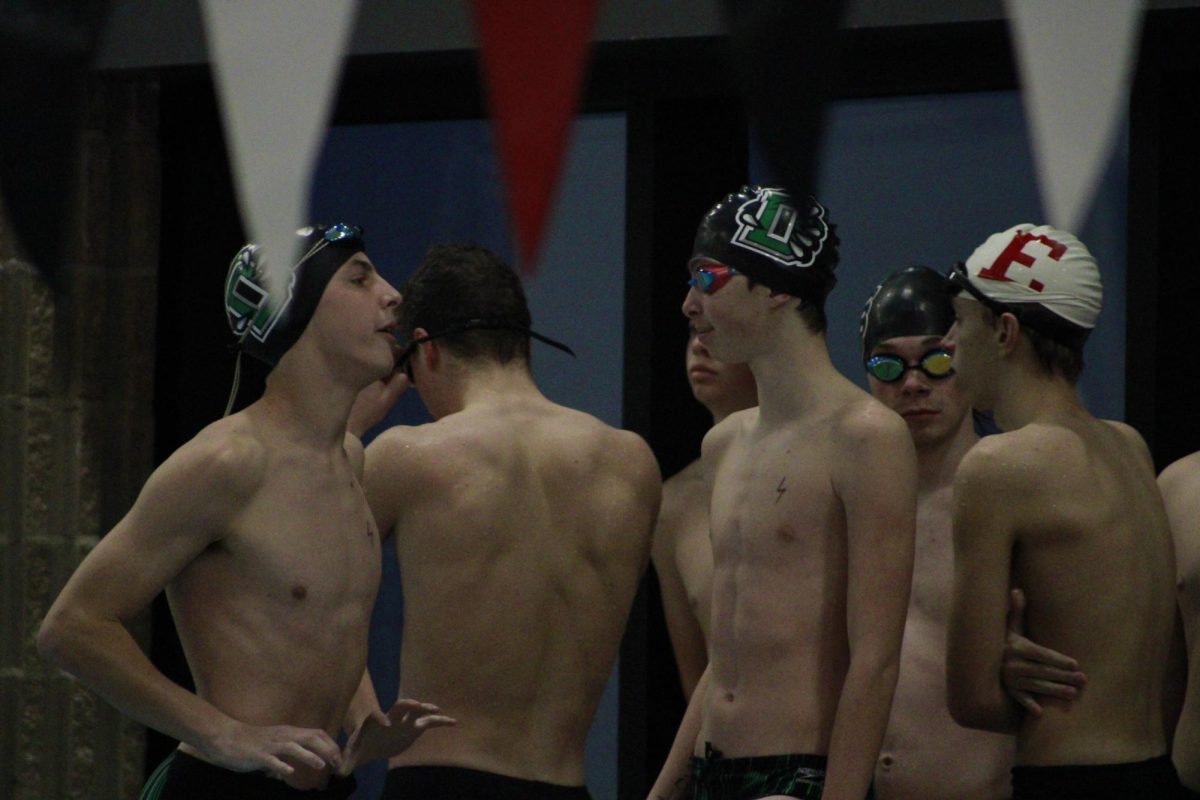 Junior Jackson Flanders (left) and sophomore Landon Holmes (right) talk before their relay. 