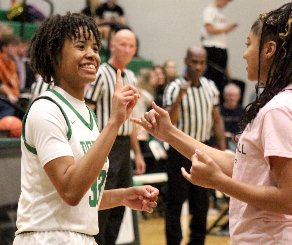 Junior Macayla Askew does a pregame handshake with a manager for the girls basketball team against Maize South.