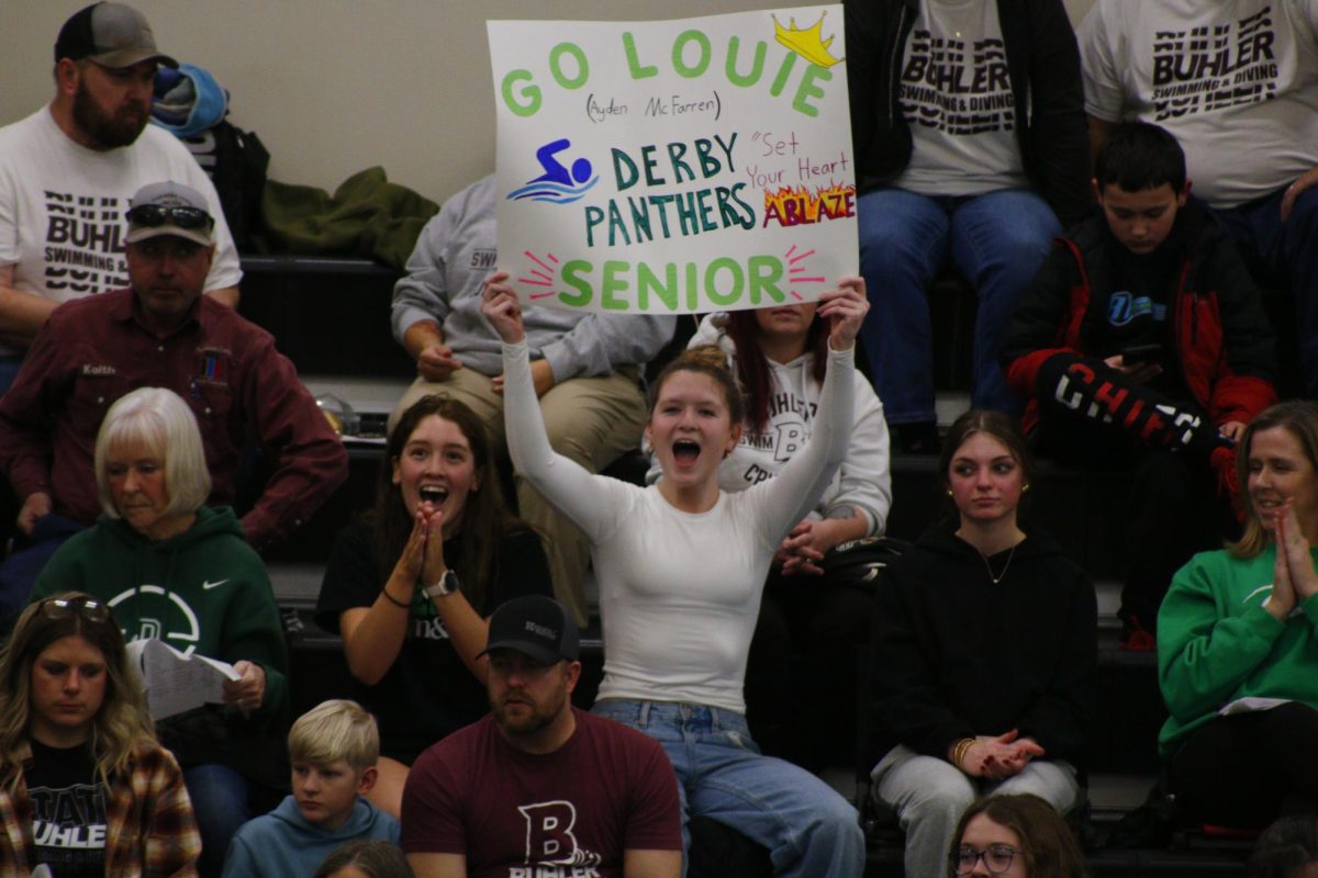 Senior Leah Rogers (left) and Sophomore Ridlee Parkhurst (right) cheer on senior swimmer. 