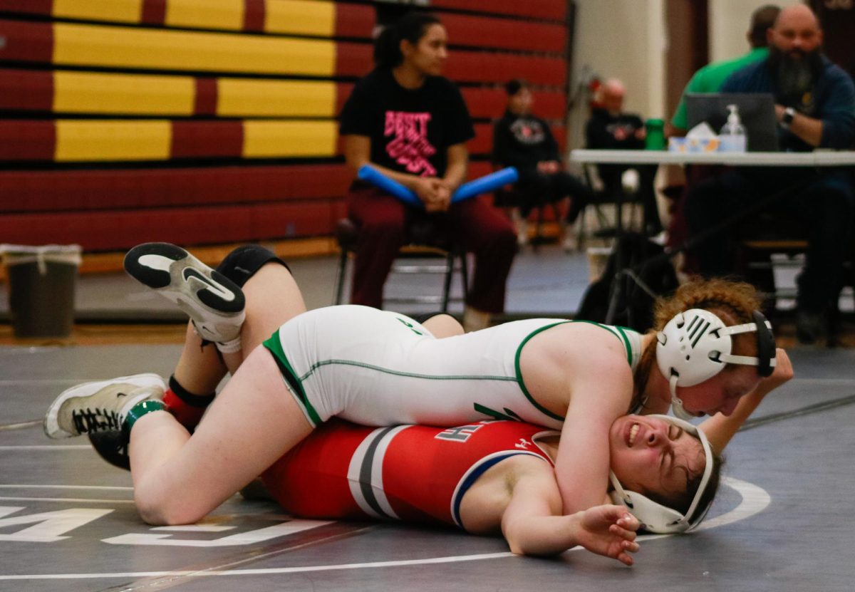 Senior Caitlin Van Praag pins her opponent.