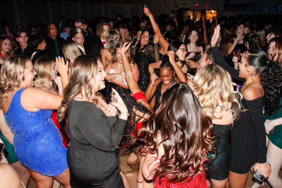 Students excitedly dance on the dance floor.