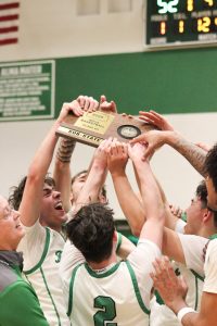 Members of the boys basketball team celebrate their 52-46 substate victory against Lawrence Free State.