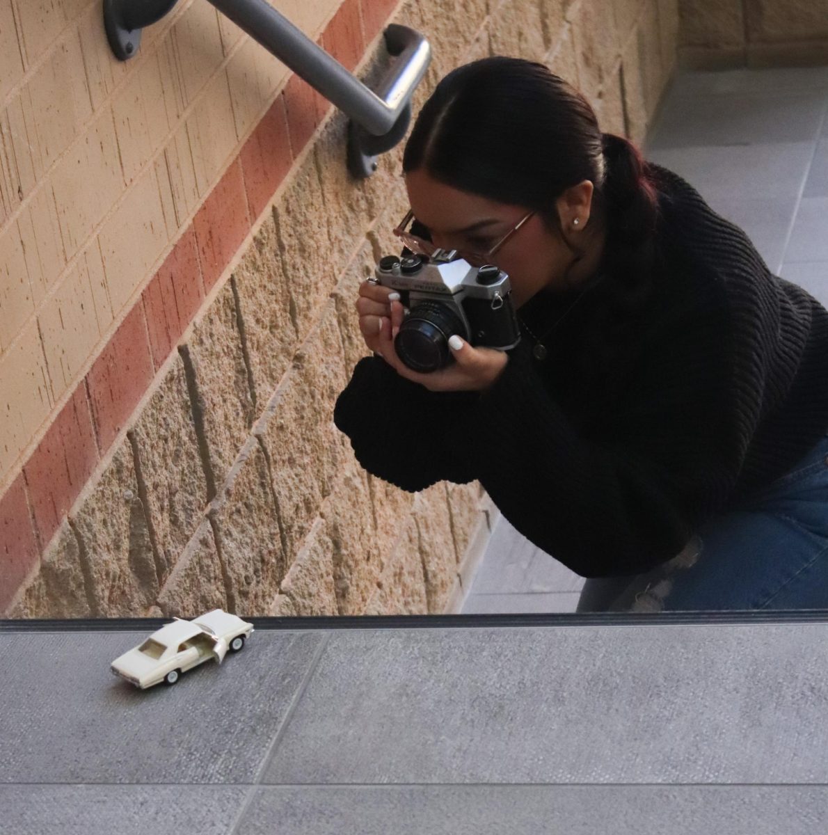 Photographer takes a picture of the toy car. 