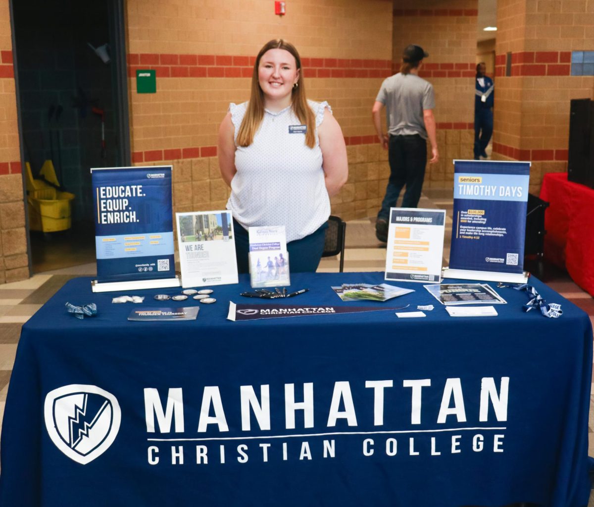 Admissions officer, Dani Hepner, sets up a table with information from Manhattan Christian College.