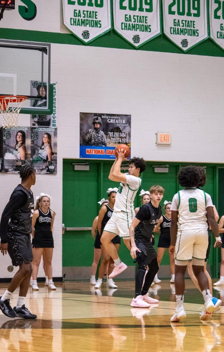 Player jumps to shoot the basketball. 