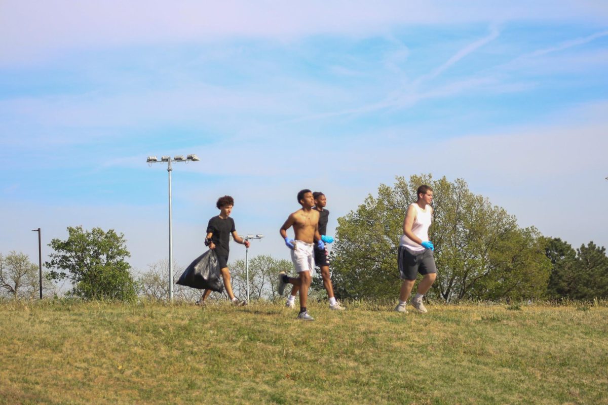 Students collect trash during team building.