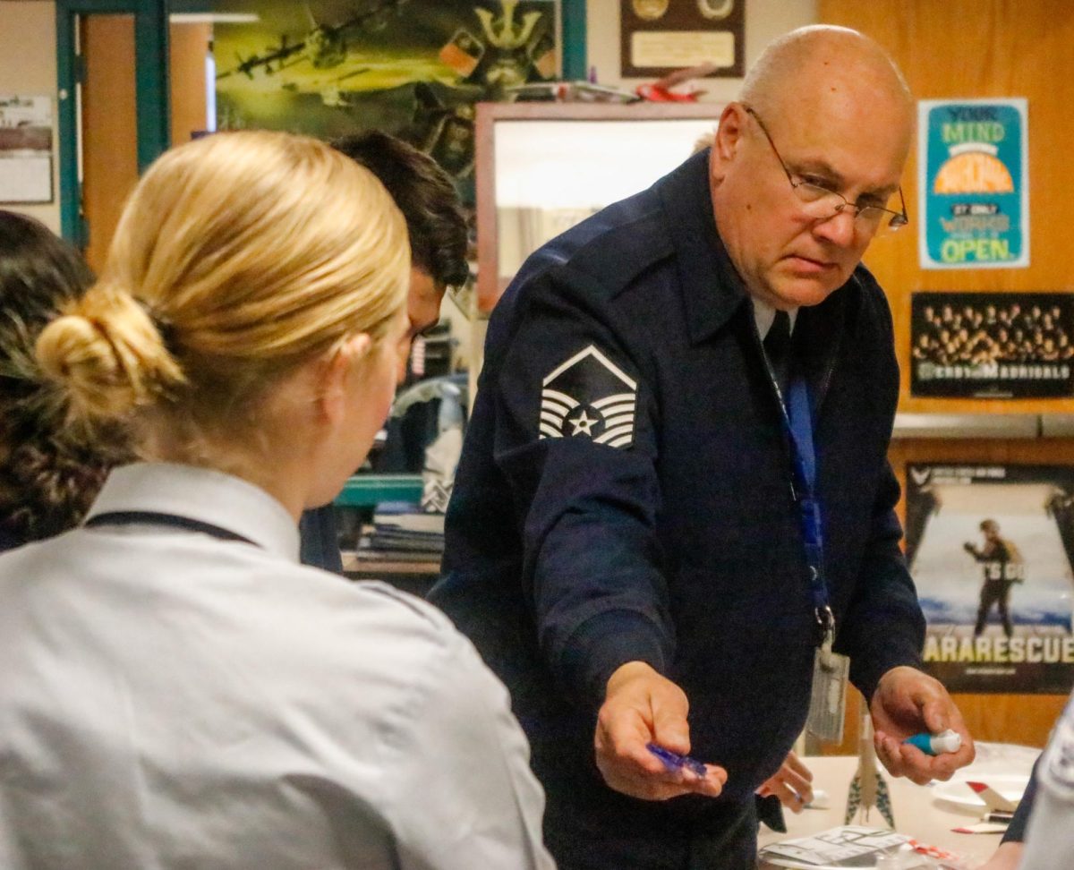 AFJROTC sponsor hands out materials.