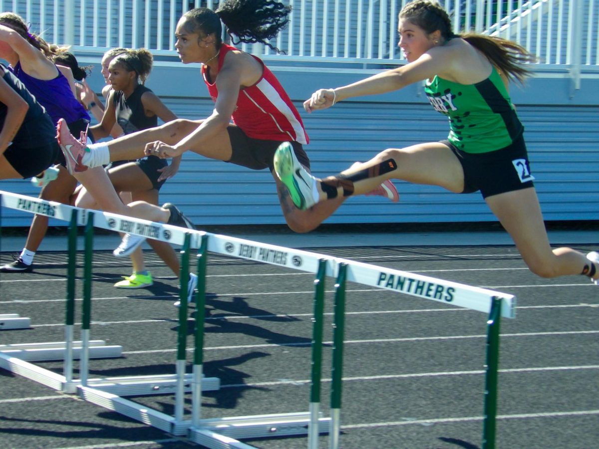 Sophomore, Aspen Garvey has a determined look on her face to finish the hurdles.