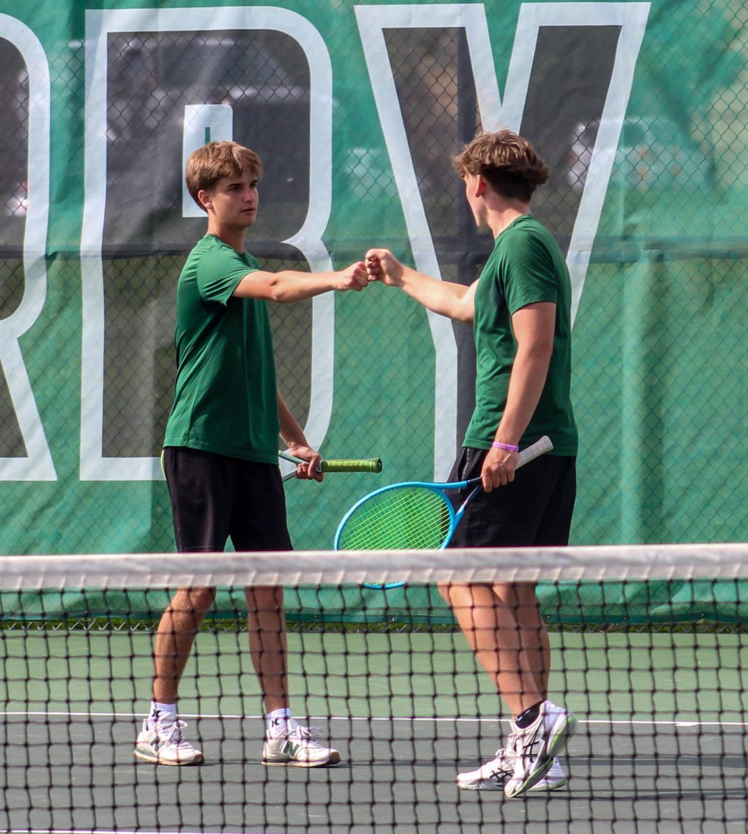 Juniors Landen Highsmith (left) and Jayce Johnson (right) fist bump during match.