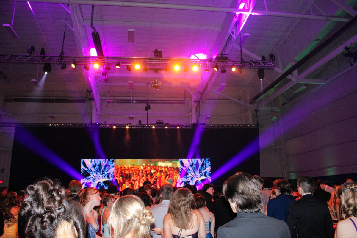 Stage lights shine above the students. 